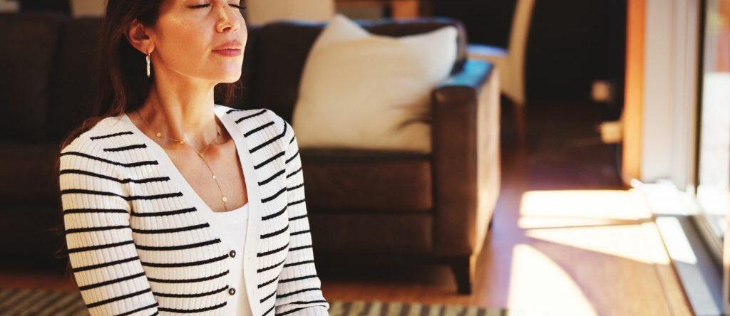 Femme pratiquant la sophrologie chez elle au quotidien pour améliorer sa qualité de vie et son équilibre intérieur