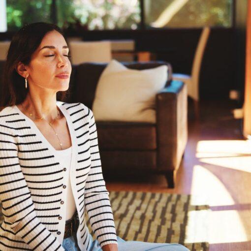 Femme pratiquant la sophrologie chez elle au quotidien pour améliorer sa qualité de vie et son équilibre intérieur