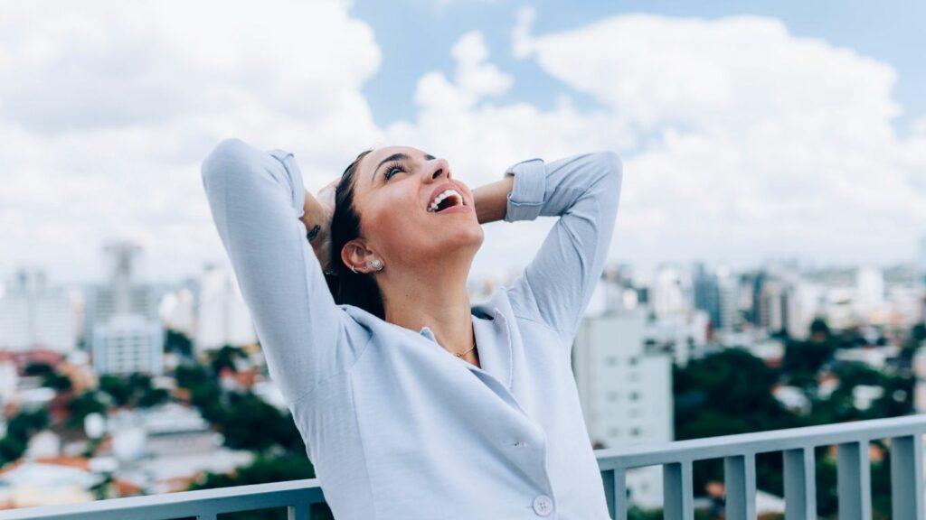 Femme souriante les mains derrière la tête, illustrant la libération des blocages émotionnels dans la méthode C.L.A.I.R.E